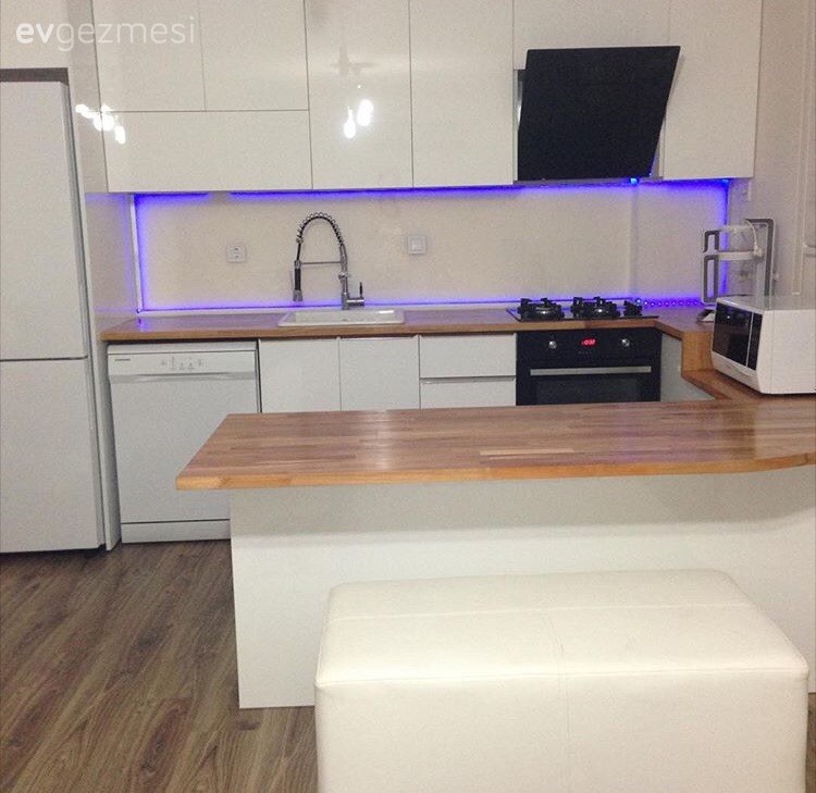 Bu mutfağın modern stil, kulpsuz dolapları ahşap tezgah ile doğal bir görünüm kazanıyor.