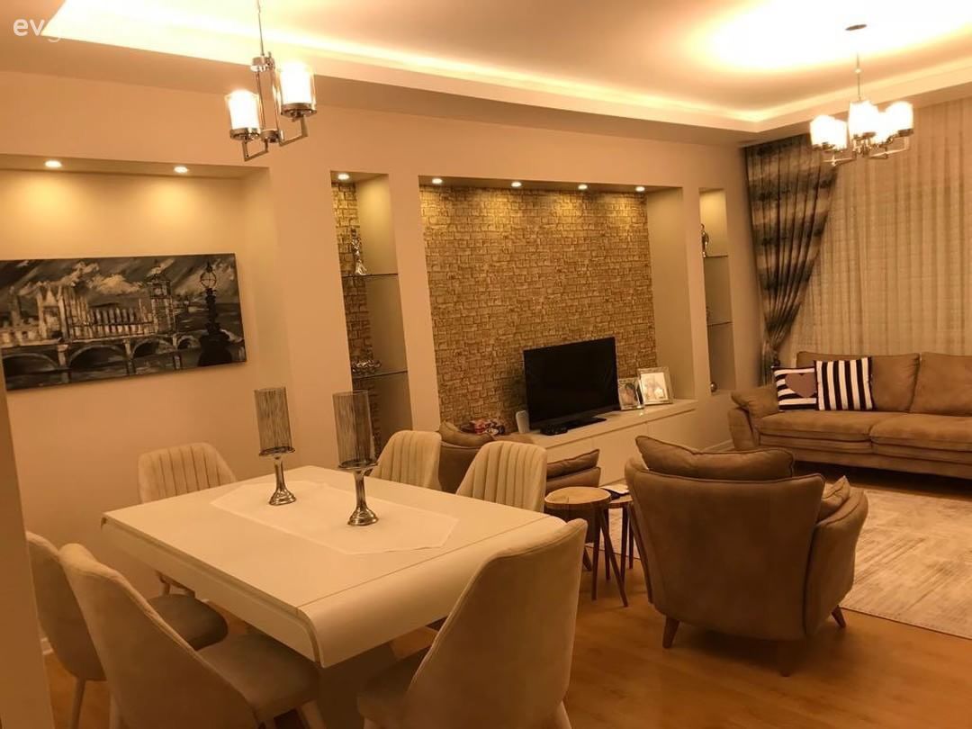 Bu salonda farklı kaynaklardan aydınlatmalar şık duvar dekorlarını öne çıkarıyor.