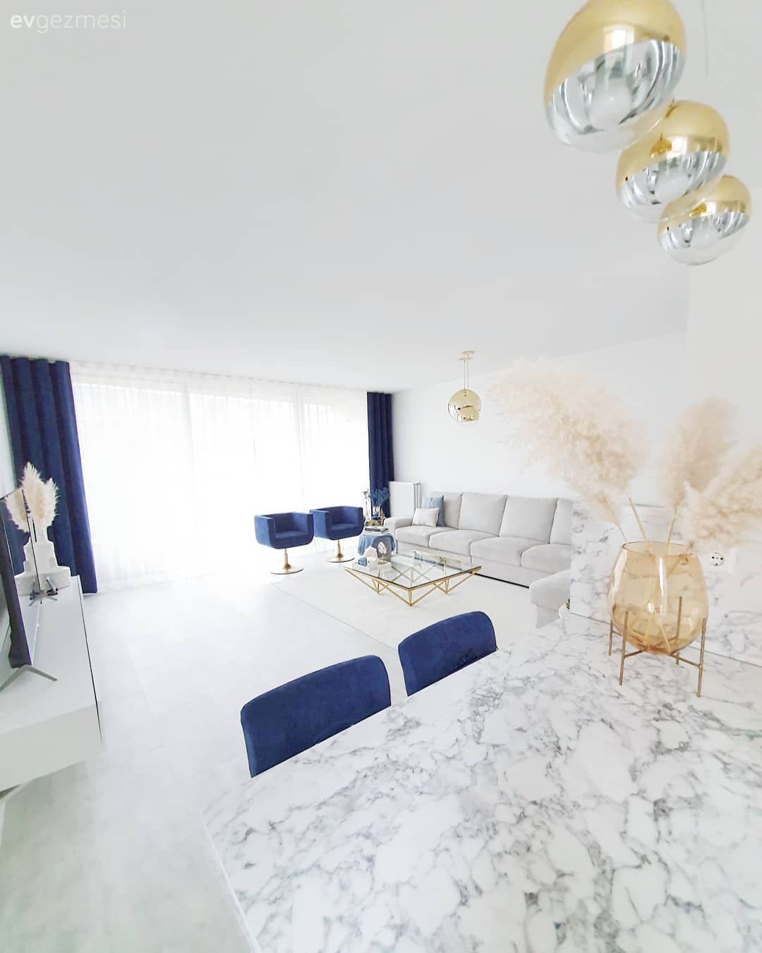 Salon, Büyük salon, Modern, Beyaz, Mavi, Köşe koltuk, Koltuk takımı, Berjer, Orta sehpa, Sehpa, Altın, Puf, Metal ayaklı sehpa, Tablo, Duvar dekorasyonu, Yapay çiçekler, Vazo, Ev Aksesuar, Sehpa üstü aksesuarı, Cam orta sehpa, Avize, Aydınlatma, Salon avizesi, Kırlent, Ev tekstili, Halı, Salon halısı, Yan sehpa, Fon perde, Perde, Tül perde, Parlament mavisi