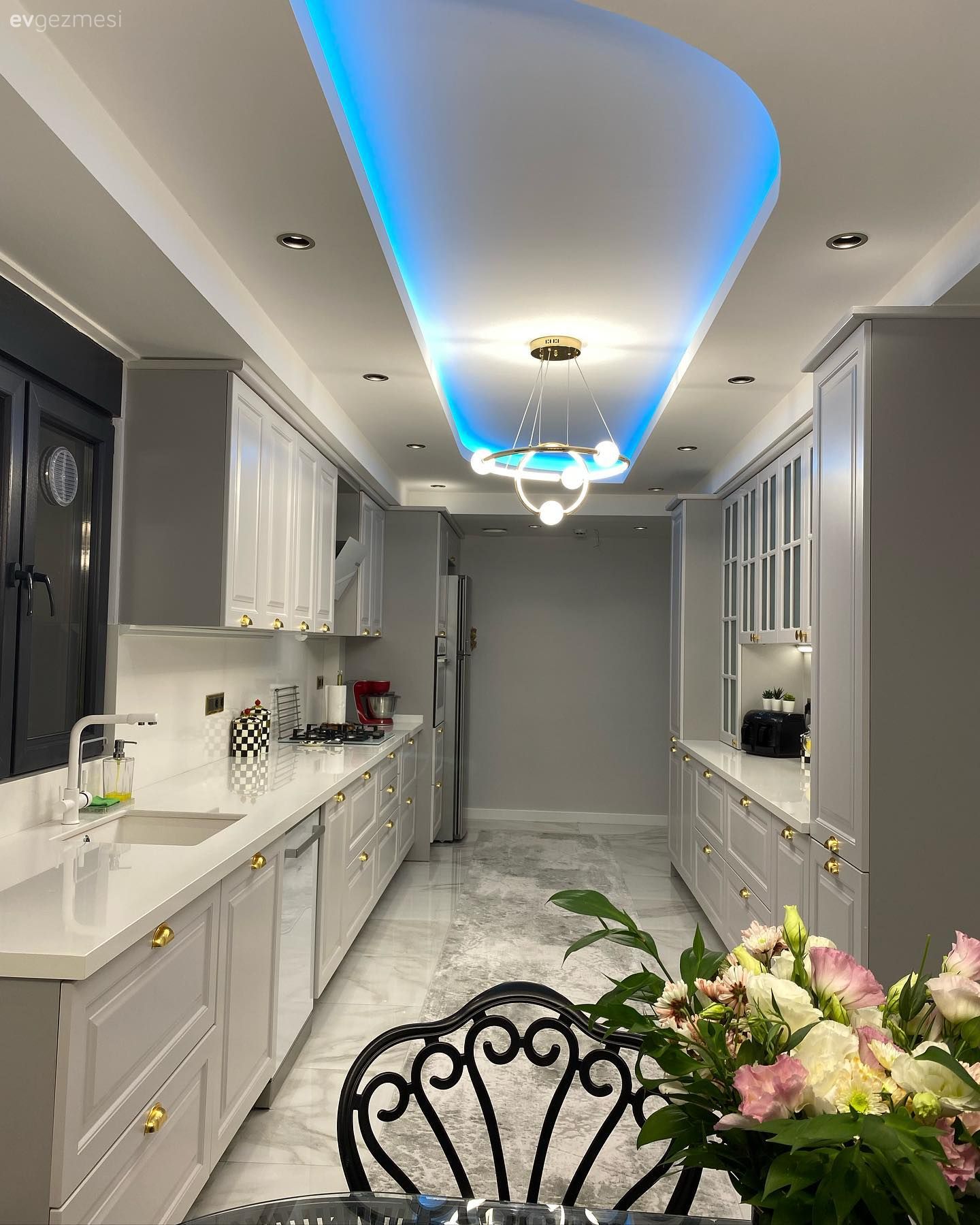 Mutfak, Beyaz, Bej, Gri, Altın, Shaker kapaklı dolaplar, Mutfak tezgahı, Mutfak tezgah arası, Tezgah arası doğal taş, Koridor tipi mutfak, Led aydınlatma, Aydınlatma, Spot aydınlatma, Siyah, Sandalye, Mutfak masası, Çiçekler, Mutfak zemin seramikleri, Gri duvar, Mutfak Avize Modelleri