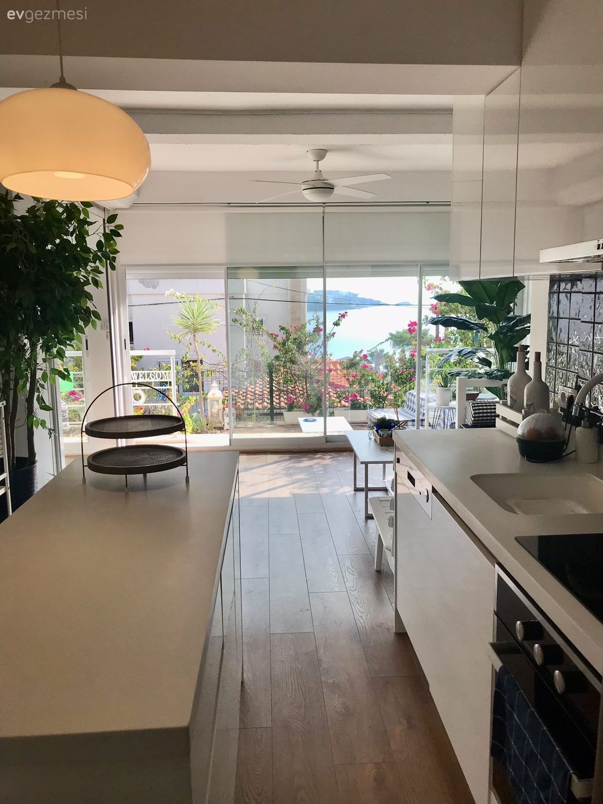 Amerikan Mutfak, Mutfak, Beyaz, Ev bitkisi, Açık konsept yaşam alanı, Stor perde, Mutfak tezgahı, Mutfak tezgah arası, Tezgah arası seramik, Avize, Aydınlatma