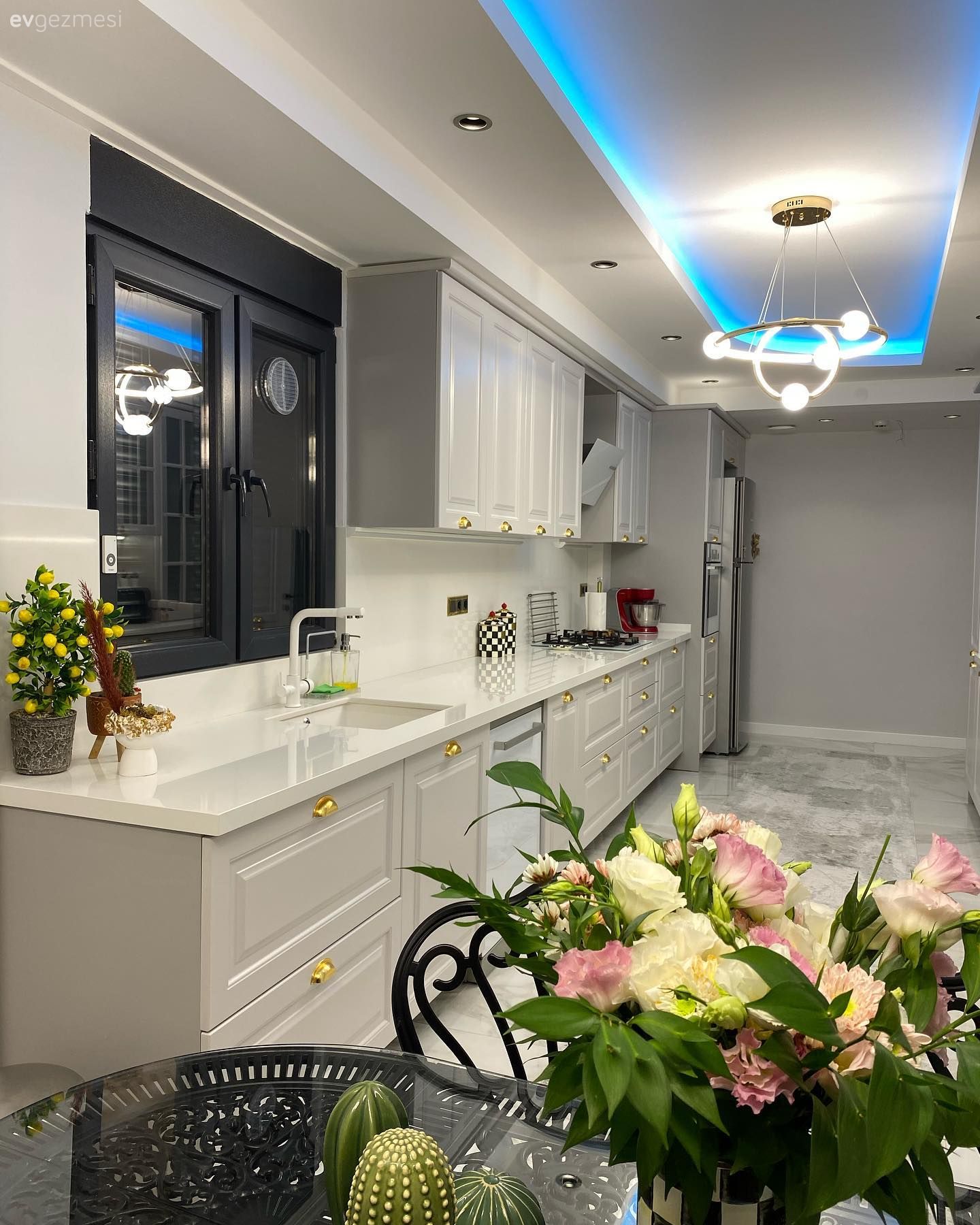 Mutfak, Beyaz, Bej, Gri, Shaker kapaklı dolaplar, Mutfak tezgahı, Mutfak tezgah arası, Tezgah arası doğal taş, Led aydınlatma, Aydınlatma, Spot aydınlatma, Mutfak aksesuarları, Çiçekler, Sandalye, Siyah, Mutfak masası, Tavan dekorasyon