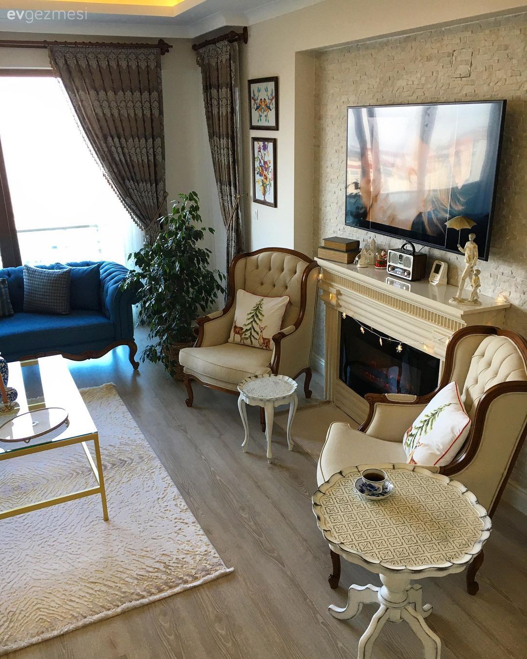 Salon, Country, Krem, Mavi, Bej, Kahverengi, Beyaz, Koltuk takımı, Berjer, Fon perde, Perde, Tül perde, Çerçeve, Şömine, Taş duvar, Duvar dekorasyonu, Parke, Halı, Salon halısı, Ev bitkisi, Cam orta sehpa, Orta sehpa, Altın, Dekoratif Objeler, Yan sehpa, Sehpa