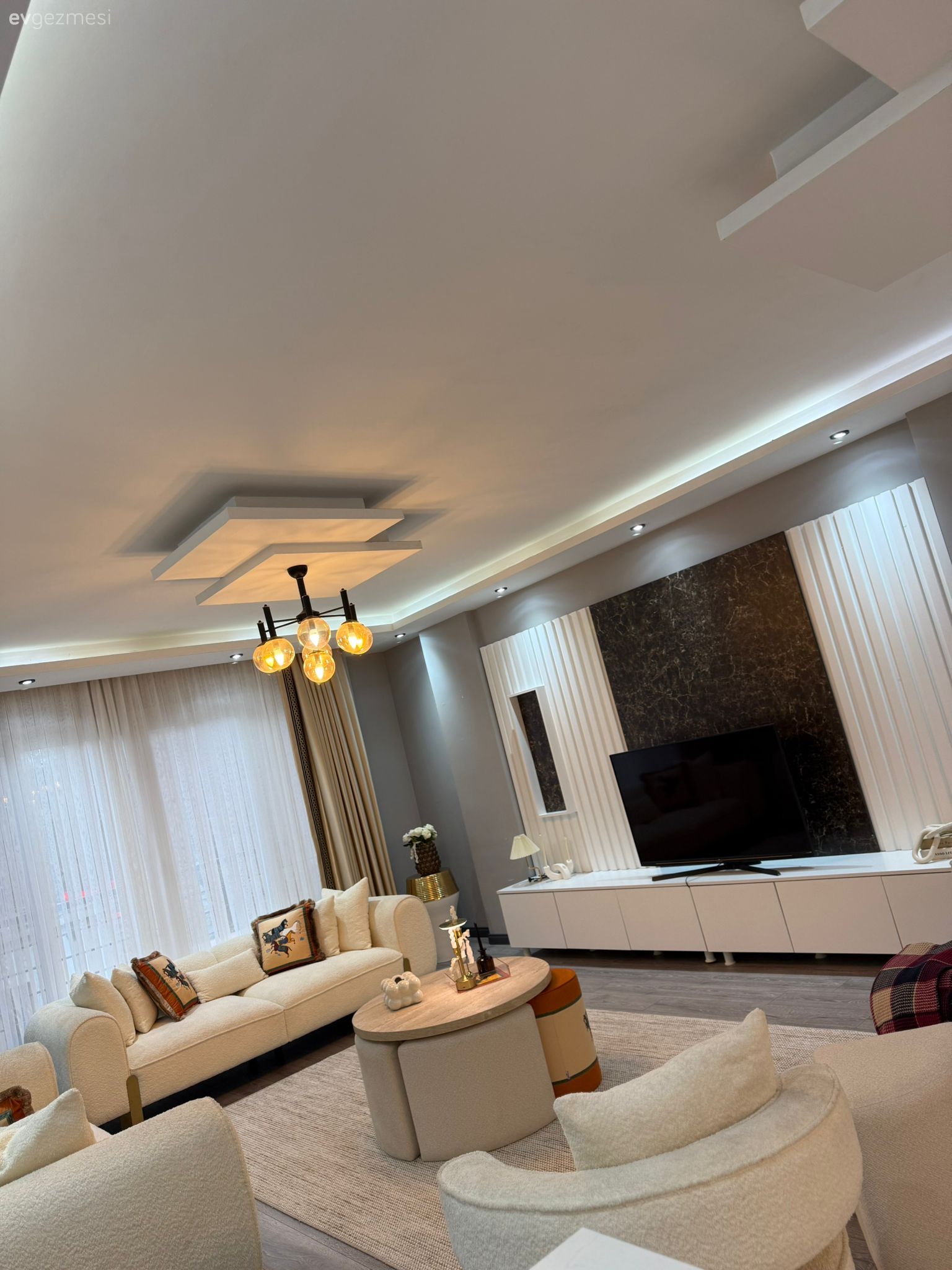 Salon, Modern, Krem, Beyaz, Bej, Beyaz koltuk, Koltuk takımı, Fon perde, Perde, Tül perde, Tv ünitesi, Tv ünitesi aksesuarları, Ev Aksesuar, Orta sehpa, Sehpa, Halı, Salon halısı, Avize, Aydınlatma, Salon avizesi, Dekoratif Objeler, Kırlent, Ev tekstili