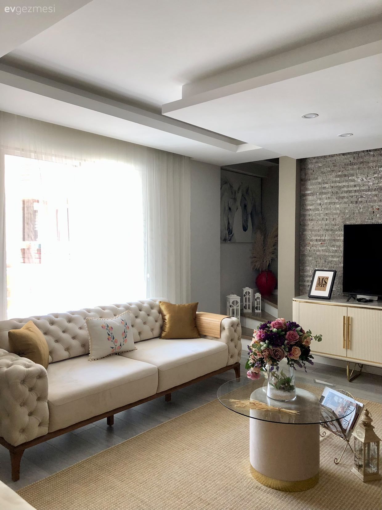 Salon, Modern, Art deko, Krem, Bej, Hardal, Altın, Kapitoneli koltuk, Koltuk takımı, Ev bitkisi, Tül perde, Perde, Kırlent, Ev tekstili, Orta sehpa, Sehpa, Jüt halı, Halı, Cam orta sehpa, Duvar saati, Duvar dekorasyonu, Tv ünitesi, Sarı