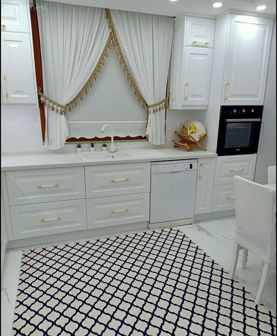 Mutfak, Klasik, Beyaz, Altın, Siyah, Shaker kapaklı dolaplar, Mutfak tezgahı, Mutfak tezgah arası, Mutfak perdesi, Stor perde, Davlumbaz, Mutfak halısı, Mutfak masası, Sandalye, Ev bitkisi, Metro seramik, Seramik, Cam Ankastre, Ankastre, Geometrik desen, Desenler