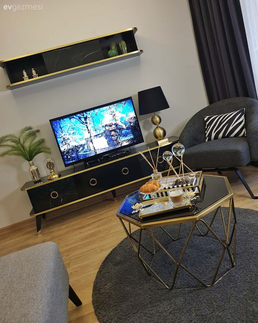 Oturma Odası, Gri, Siyah, Altın, Köşe koltuk, Koltuk takımı, Yuvarlak halı, Halı, Orta sehpa, Sehpa, Metal ayaklı sehpa, Kırlent, Ev tekstili, Tablo, Duvar dekorasyonu, Tv ünitesi, Tv ünitesi aksesuarları, Ev Aksesuar, Abajur, Aydınlatma, Vazo, Fon perde, Perde, Dekoratif Objeler, Berjer